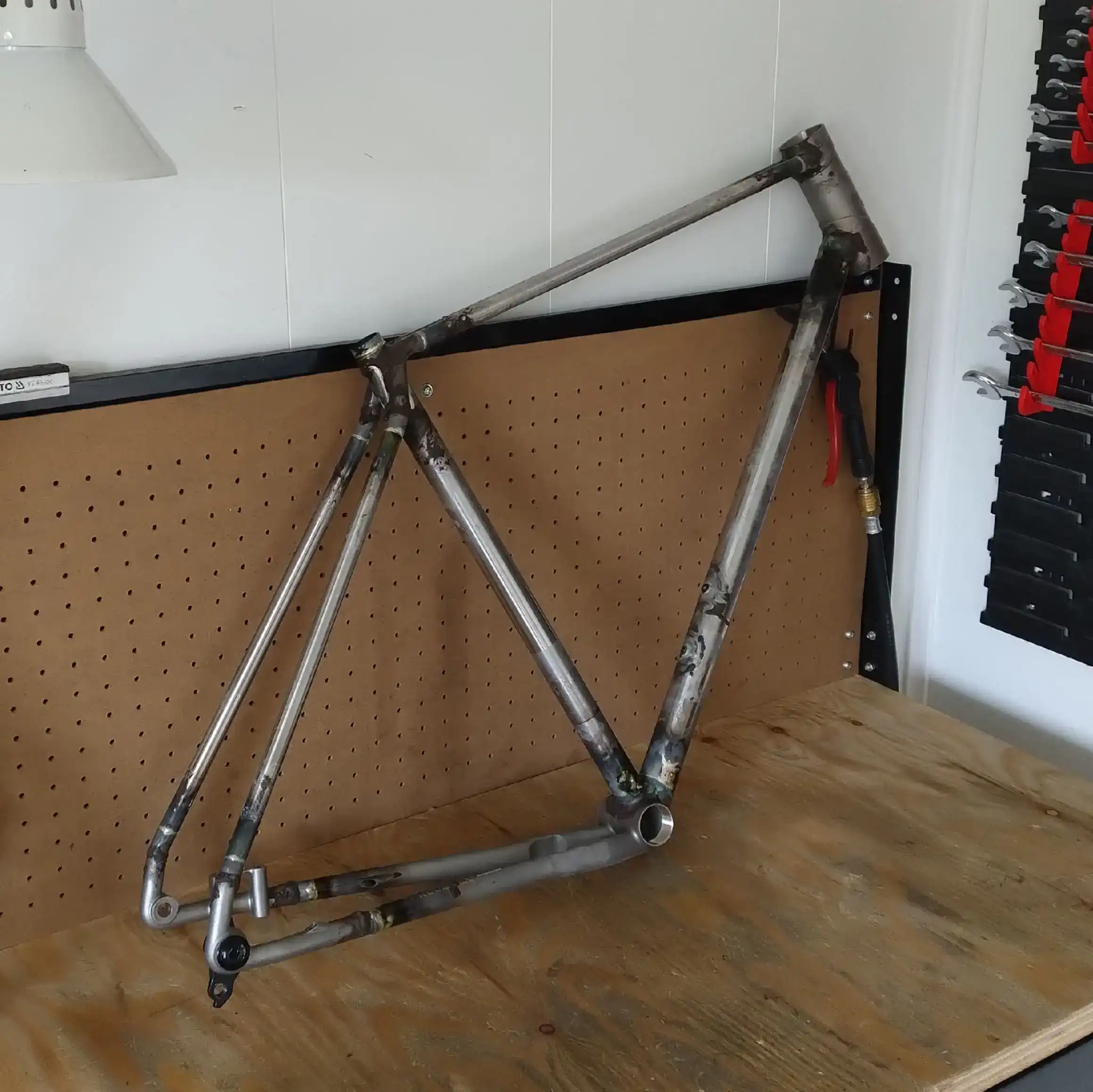 Raw welded titanium bike frame during fabrication in the workshop