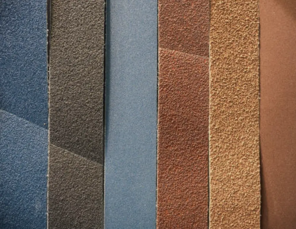 Hand-sanded metal surface finish samples with different grit levels and texture variations