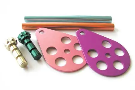 Type II decorative anodizing showing colorful anodized aluminum plates, rods, and machined parts