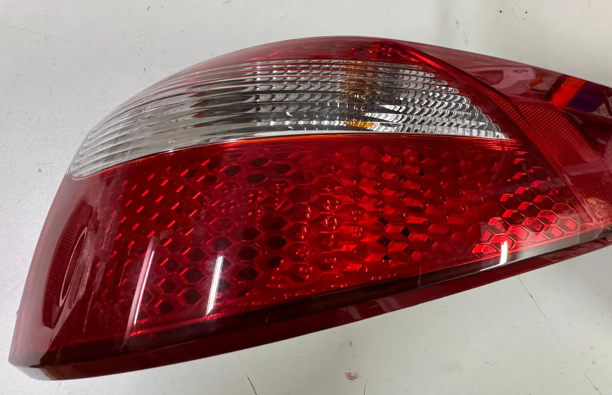 Automotive tail light lens with red and clear sections