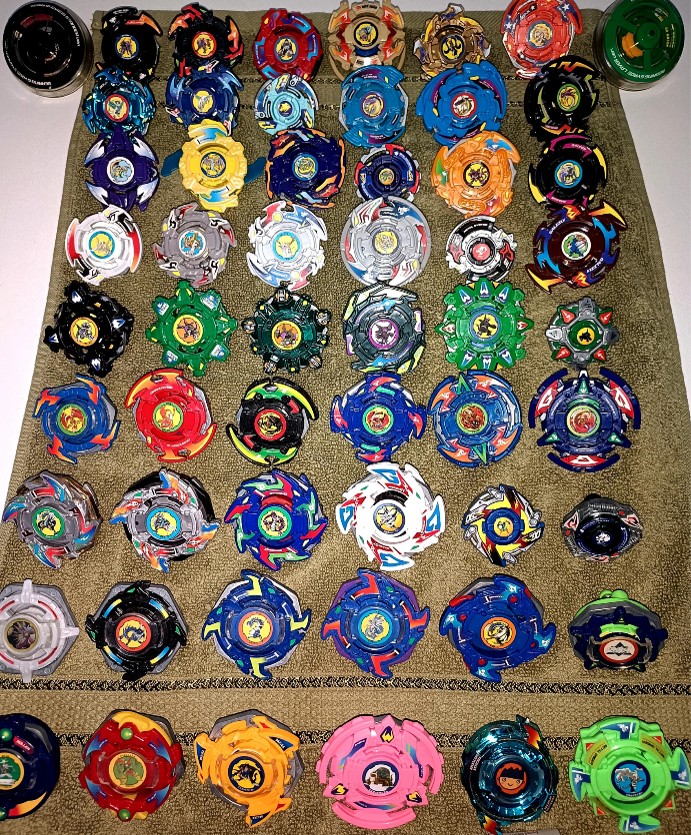 A collector's collection of Beyblade spinning tops displayed together.