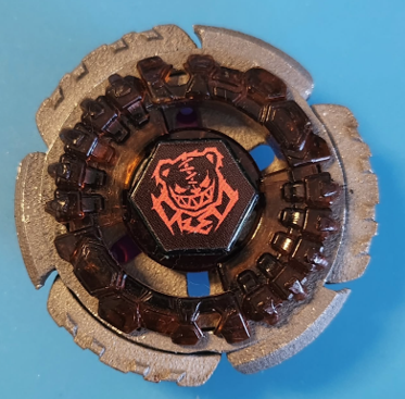 Unfinished stainless steel 3D printed Beyblade with a rough surface texture.